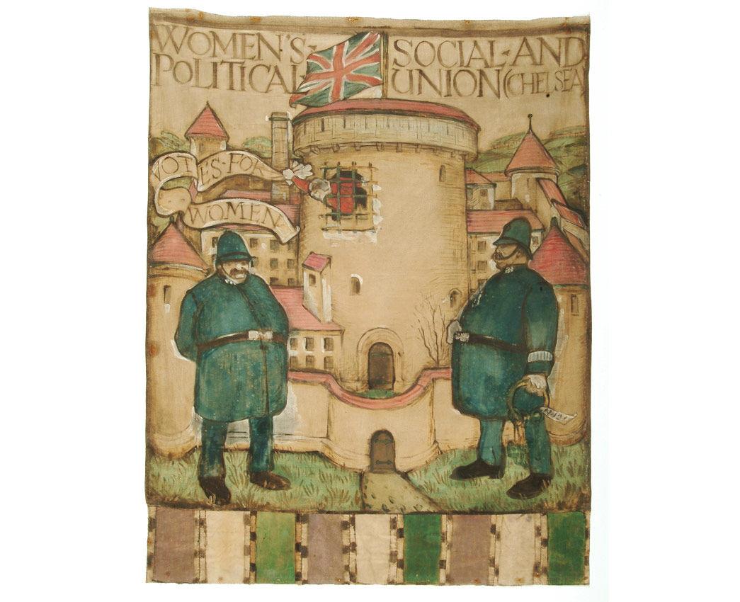 This banner was designed for the Chelsea branch of the Women's Social and Political Union (W.S.P.U) by Herman Ross. It was first unfurled at the Queen's Hall on 17 June 1908 in preparation for Women's Sunday on 21 June. The painted banner depicts two policemen guarding the entrance to Holloway prison, out of which a suffragette prisoner can be seen waving a banner with the slogan 'Votes for Women'. The base of the banner is decorated with the W.S.P.U's colours: purple, white and green. By 1911 the Chelsea branch of the union had opened a shop at 308 King's Road for the sale of suffragette merchandise. The shop's basement became a workshop for the design and production of campaign banners.

