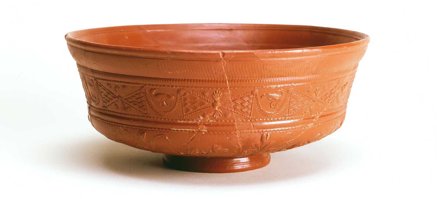 This glossy red Roman bowl is decorated with small birds flying between leaf tips.