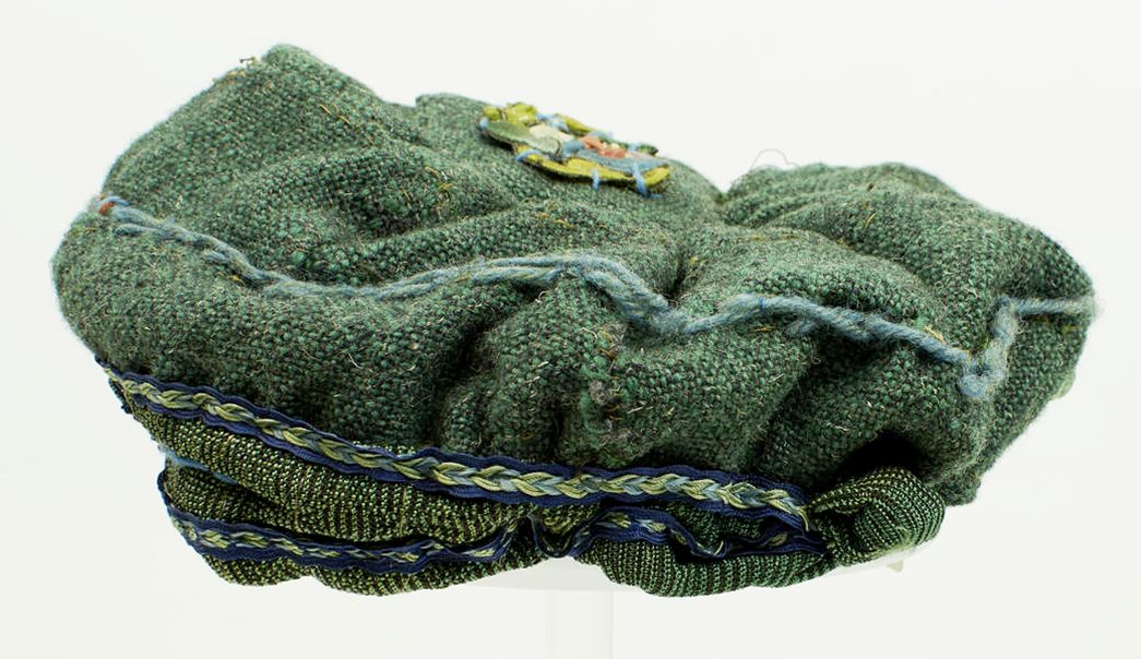 The woollen hat was mad by artist Estella Canziani, with a green warp and a dark grey weft. (ID no.: 69.158/c)