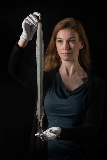 Curator holding a Bronze Age sword.
