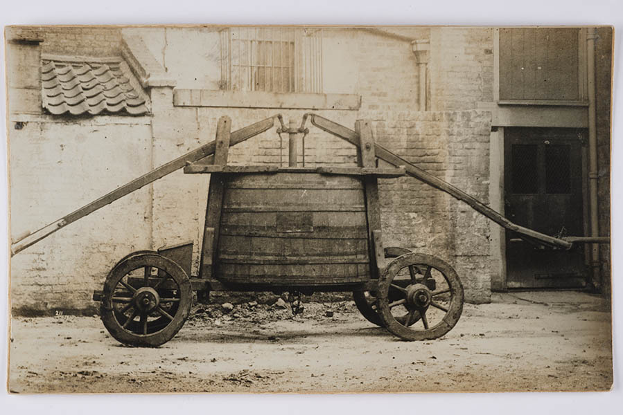 19th century photo showing a fire engine which was built by John Keeling, c1679. It is basically a barrel on wheels with a pumping mechanism operated using the large arms.  