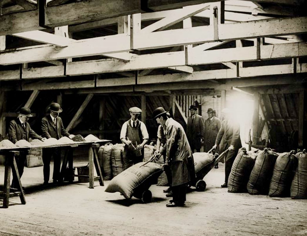 Sampling sacks of raw sugar
Sacks of raw sugar being sampled and marked in No. 2 Warehouse, West India Dock, c1930. (Courtesy: Port of London Authority Archive)
