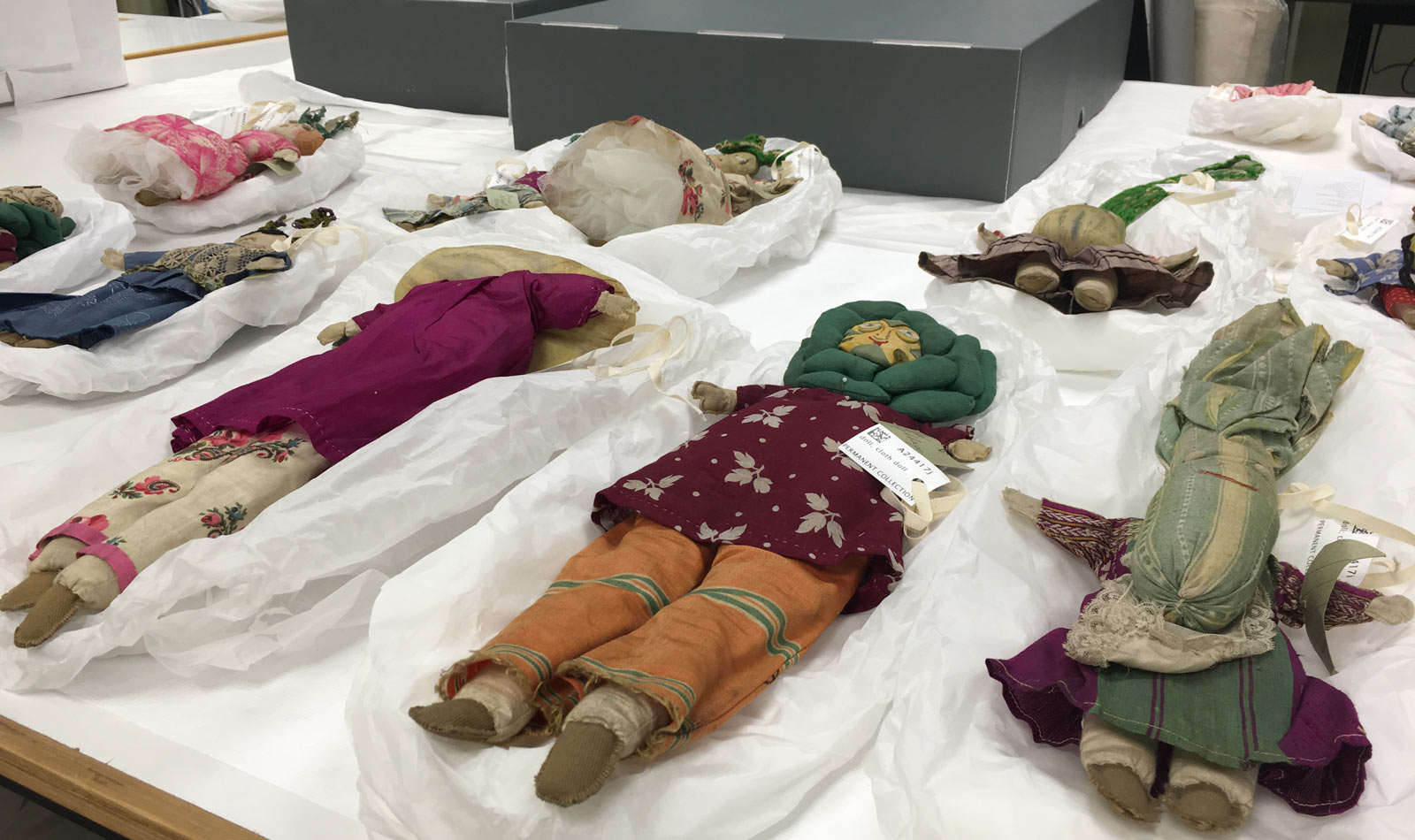 The dolls laid out on tissue padding waiting for humidification to remove creasing.