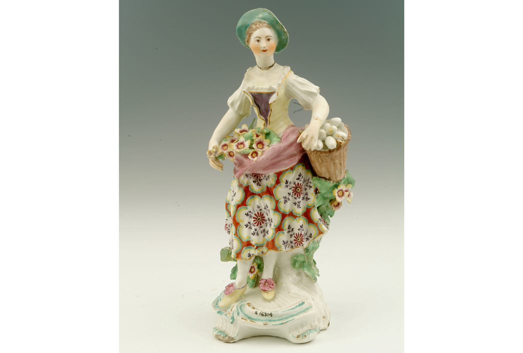 A soft-paste porcelain figure of a girl with a basket of eggs, decorated with polychrome enamels. (ID no.: A16314)