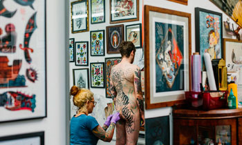 Tattoo artist working on a client