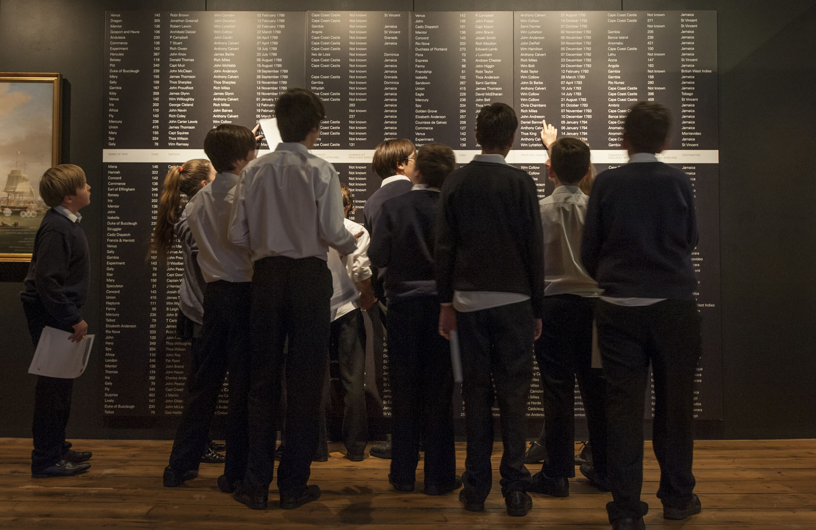 Young visitors to the Museum of London Docklands view the names of slave ships that sailed from London.